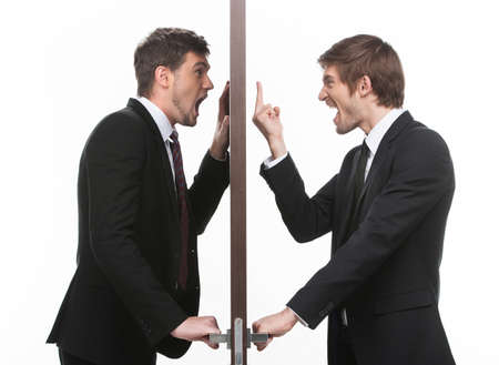 Open the door  Two angry young business standing at the both sides of the door while one of them gesturingの写真素材