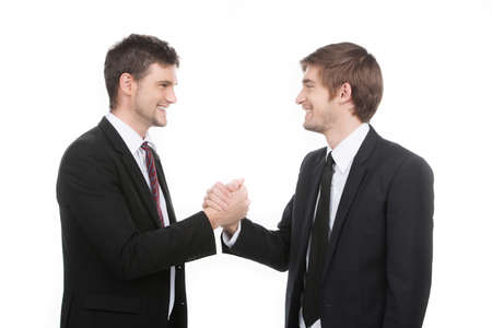 Business partners  Two cheerful business people shaking hands while standing isolated on whiteの写真素材
