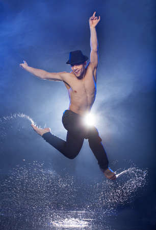 Wet dancer. Young male dancer in black fedora dancing on the wet floorの写真素材