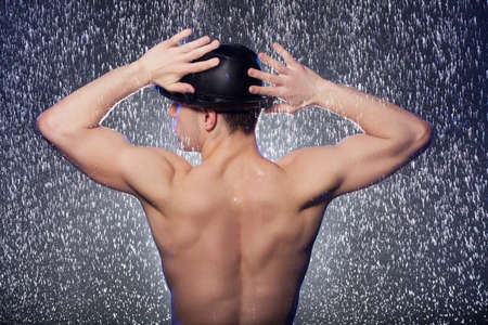 Perfect body. Rear view of young men in black fedora standing under the rainの写真素材
