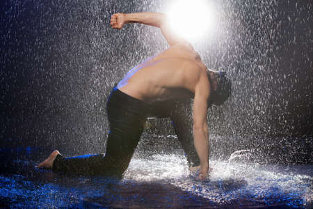 Hitting the floor. Young men hitting the floor while standing under the rainの写真素材