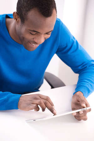 Working at the digital tablet. Top view of cheerful African descent men Working at the digital tabletの写真素材