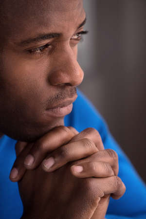 Waiting for inspiration. Confident African descent men sitting with his hands clasped and looking awayの写真素材