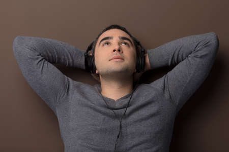 Man listening to the music. Relaxed middle-aged man listening to the music with his head in handsの写真素材