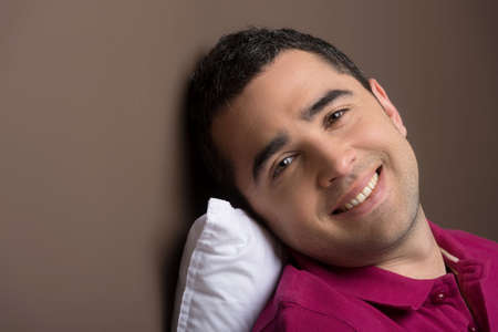 Man relaxing. Relaxed middle-aged man leaning on the pillow and smiling at cameraの写真素材