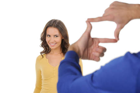 Finger frame. Beautiful young women smiling against white background while someone looking at her through a finger frameの写真素材
