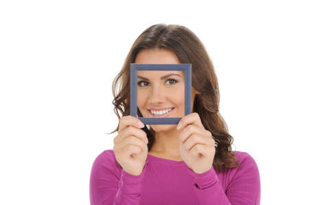 Women with picture frame. Beautiful young women smiling and looking through a picture frame while...