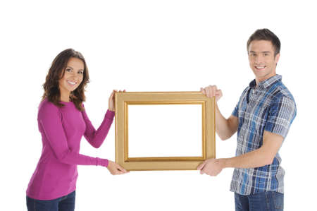 Couple with frame. Beautiful young couple holding a picture frame and smiling at camera while...
