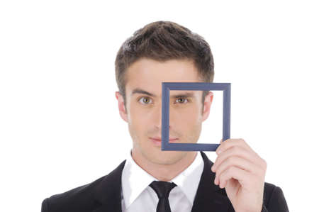 Businessman in picture frame. Confident young man in formalwear looking through a little picture frame while isolated on whiteの写真素材