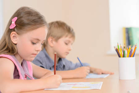 Diligent young learners. Confident pupils writing something in their notepadの写真素材
