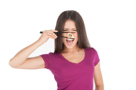 Woman with sushi. Beautiful mixed race woman holding sushi in chopsticks by front of her eyes while standing isolated on whiteの写真素材