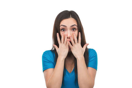 Terrified woman. Shocked young woman covering her mouth with hands and looking at camera while...