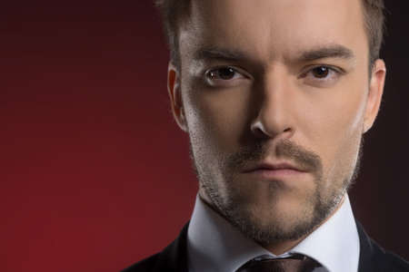 Confidence businessman  Portrait of confident young businessman looking at camera while isolated on redの写真素材