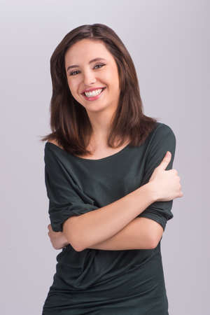 Beautiful young women. Beautiful young women smiling while standing isolated on greyの写真素材