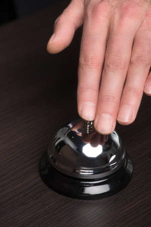 Service bell. Close-up of the hand ringing a service bell