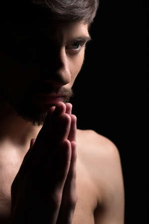Young man praying. Portrait of a young man prayingの写真素材