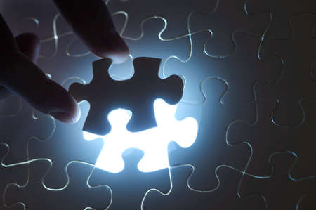 A hand fitting the last piece of puzzle in place.