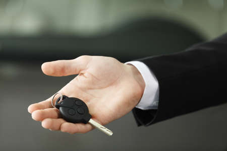 Please, drive carefully! Close up shoot of the hand holding car keysの写真素材