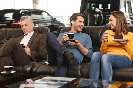 They need some break to make a right choise. Three car dealership customers having a break before...