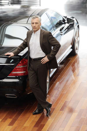 A man standing in front of his new car.の写真素材