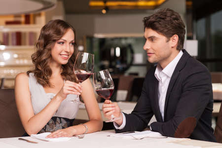 Loving couple celebrating at the restaurant. Looking happy and romanticの写真素材