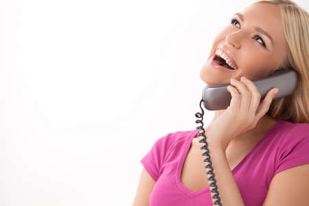 Hello! Beautiful young women talking at phone and smiling while standing isolated on white