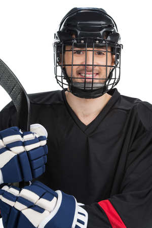 Smiling hockey player in uniform. Standing isolated on whiteの写真素材