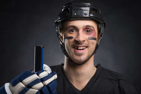 Funny hockey player smiling with one tooth missing. Isolated on blackの写真素材