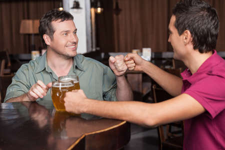 Friends forever. Two friends drinking beer at the barの写真素材