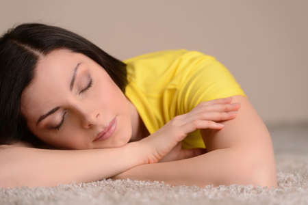 Sleeping on the floor. Close-up of beautiful middle-aged women sleeping on the floorの写真素材