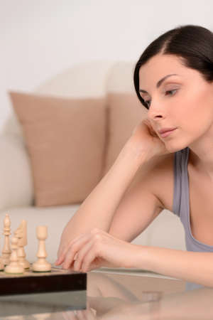 Women playing chess. Beautiful middle-aged women playing chess at homeの写真素材