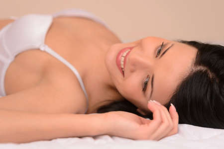 Beauty in bed  Beautiful young woman in lingerie lying on the sofaの写真素材