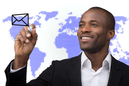 Businessman drawing envelope on world map backgroundの写真素材