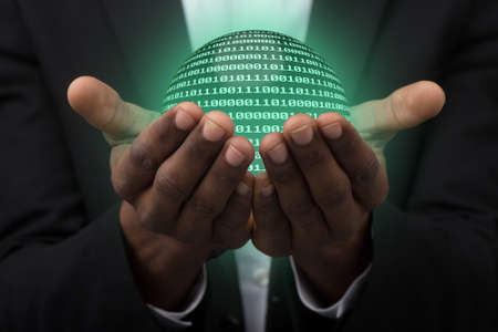 businessman holding globe made from binary code.の写真素材