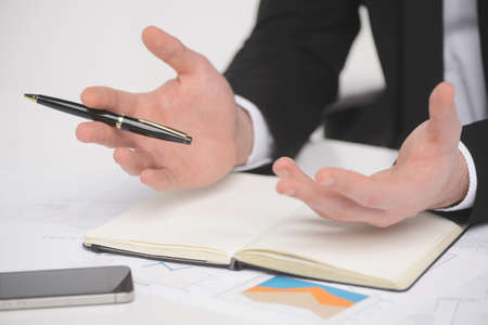 Businessman gesturing. Close-up of businessman gesturing with a pen in his handの写真素材
