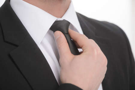 Adjusting necktie. Close-up of businessman adjusting his necktieの写真素材