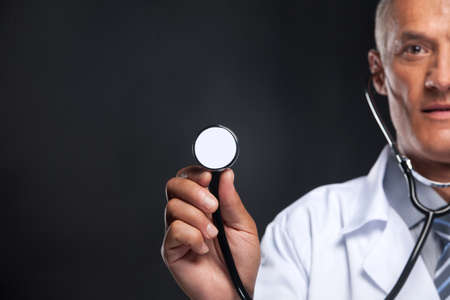 Close up of stethoscope in doctorâs hand. Blur face on backgroundの写真素材