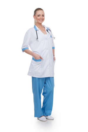 Smiling nurse full length isolated over white background. Looking at cameraの写真素材
