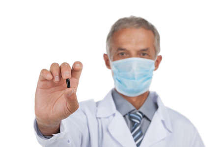 Portrait of mean age doctor. Holding black pill in hand. Isolated on whiteの写真素材