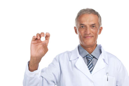 Smiling  adult doctor holding white pill in hand. Close up isolated on whiteの写真素材