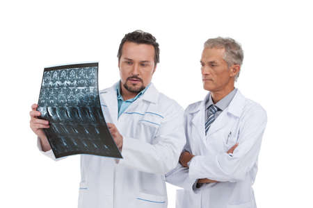 Two experienced doctors discussing X-ray. Standing isolated on whiteの写真素材