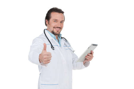 Attractive confident doctor showing thumb up. Standing isolated on white and smileの写真素材
