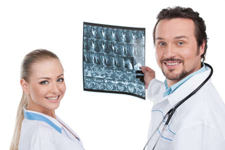 Smiling male and female doctor with Roentgen on background. Standing isolated on whiteの写真素材