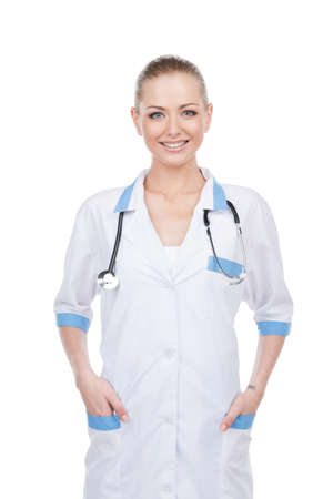 Beautiful smiling young nurse standing isolated on white. Looking at cameraの写真素材