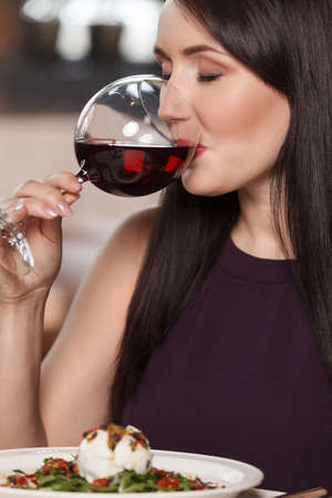 Good wine. Portrait of beautiful mature women drinking wine in restaurantの写真素材