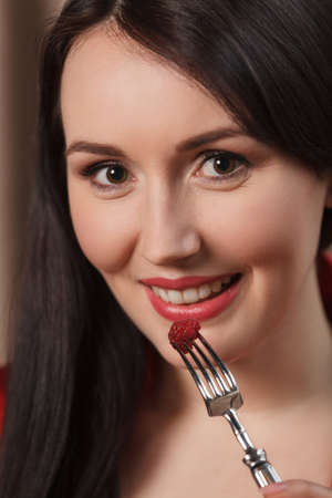 Eating raspberry. Close-up of women eating raspberry using forkの写真素材