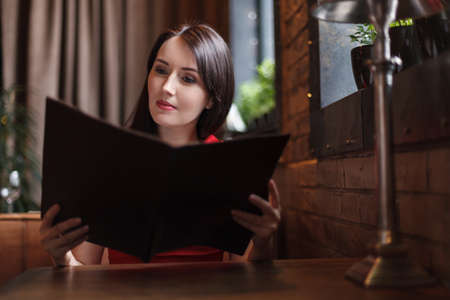 Women reading Menu. Beautiful middle-aged women reading Menu at the restaurant