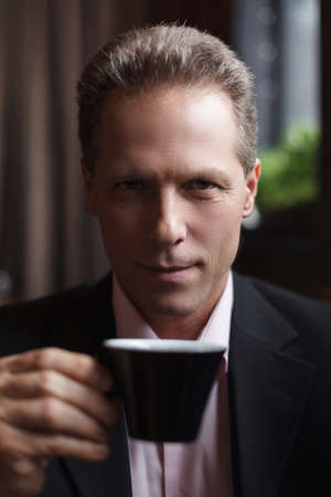 Man drinking coffee. Confident mature businessman drinking coffee at the restaurantの写真素材
