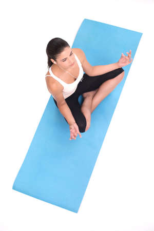 Lotus Position. Top view of beautiful young women sitting in a lotus position and meditatingの写真素材