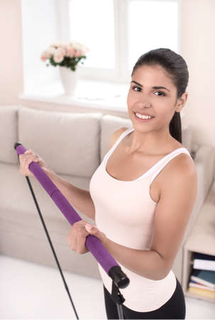Sport at home. Top view of beautiful young women in sports clothing exercising at home and looking at cameraの写真素材